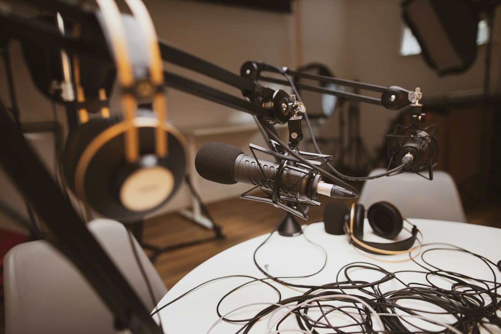 Mesa de podcast con micrófonos en brazos y auriculares